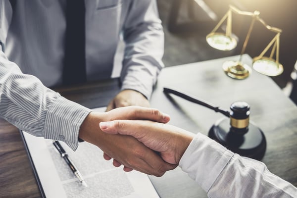 Hiring an attorney. Two people shaking hands.